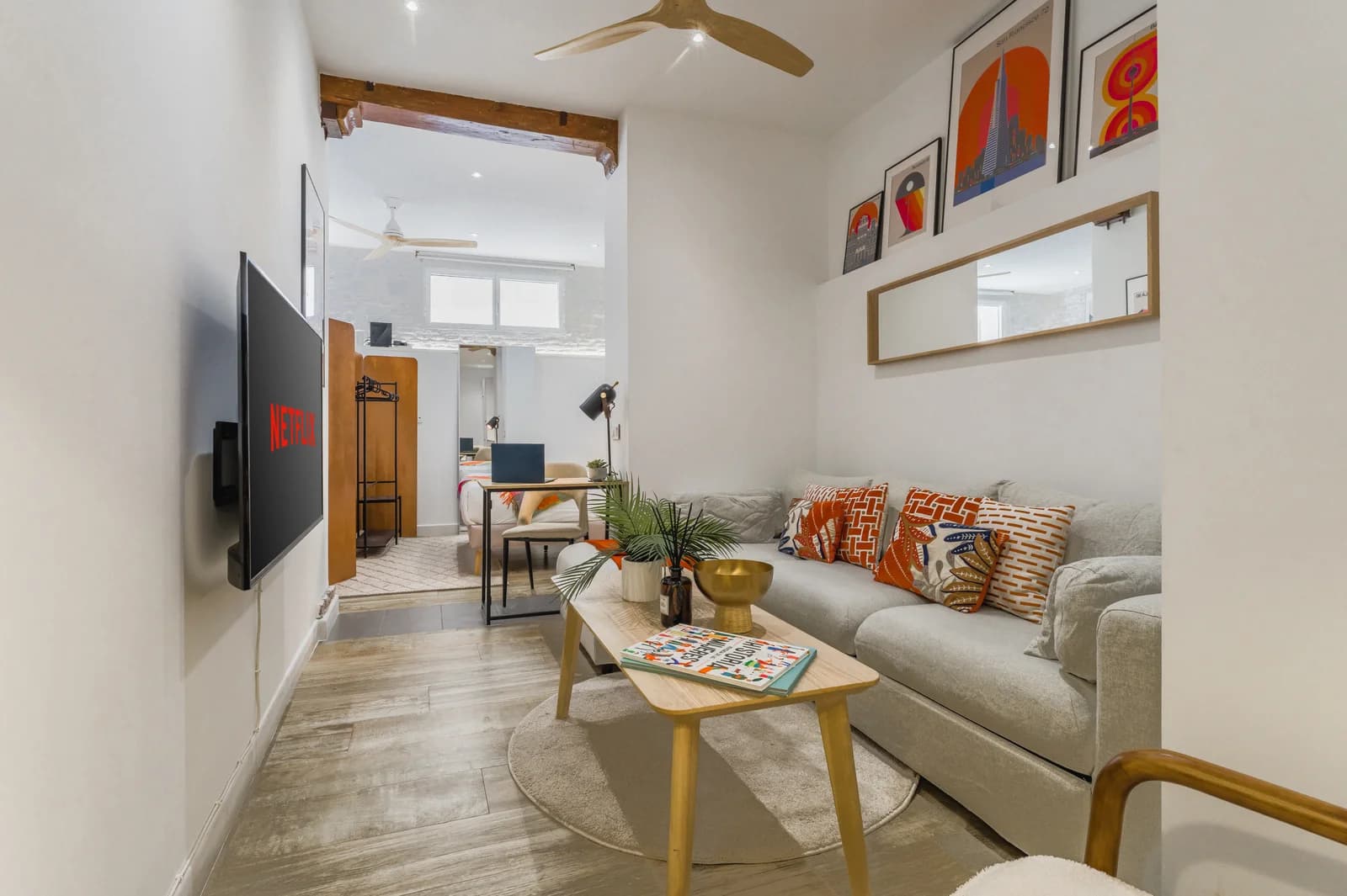 Sectional sofa with patterned cushions under high ceiling and gallery prints