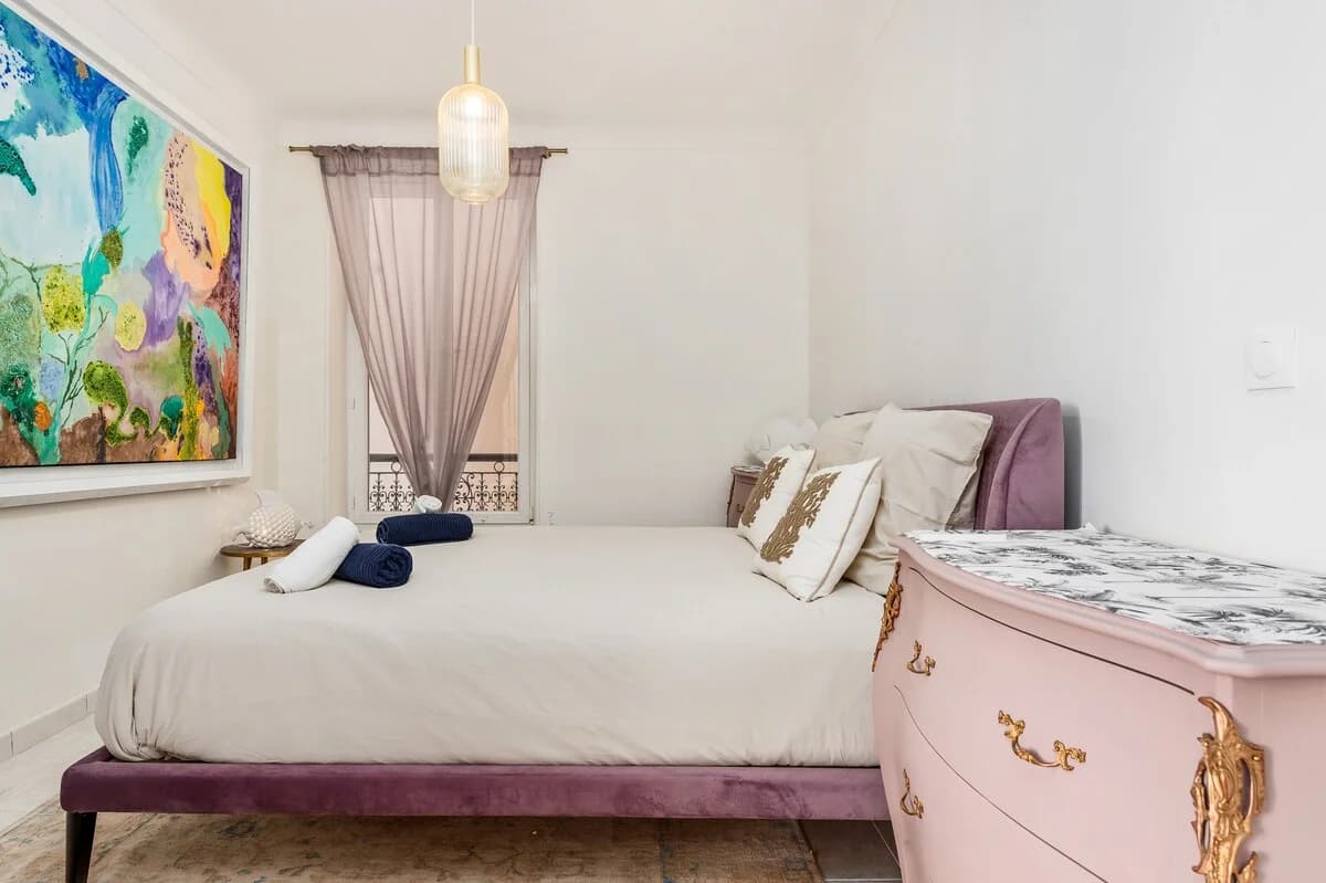 Bedroom with velvet purple bed, rococo dresser and balcony curtain