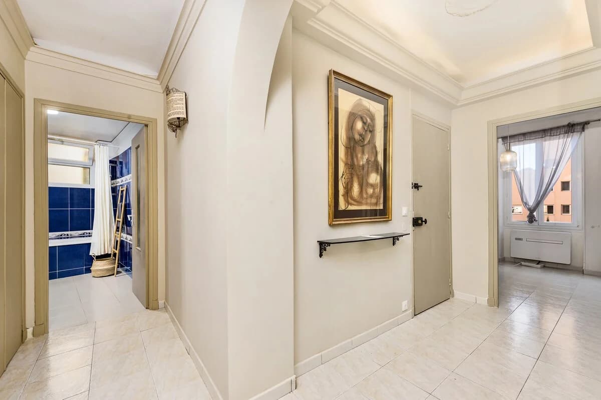 Hallway with vaulted ceiling, gilt portrait and arched doorways