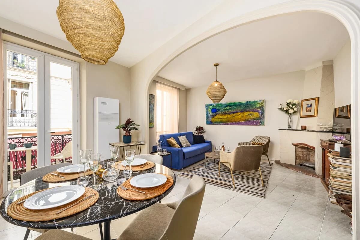 Lounge with blue velvet sofa and abstract painting beside French doors