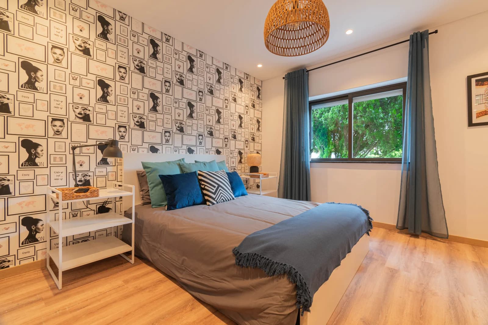 Portrait-print bedroom with green leafy view through wide window