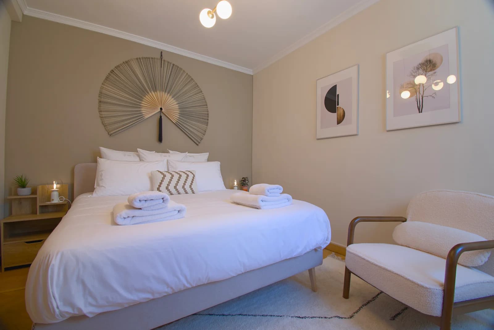 Master bedroom with boucle armchair and warm globe lighting