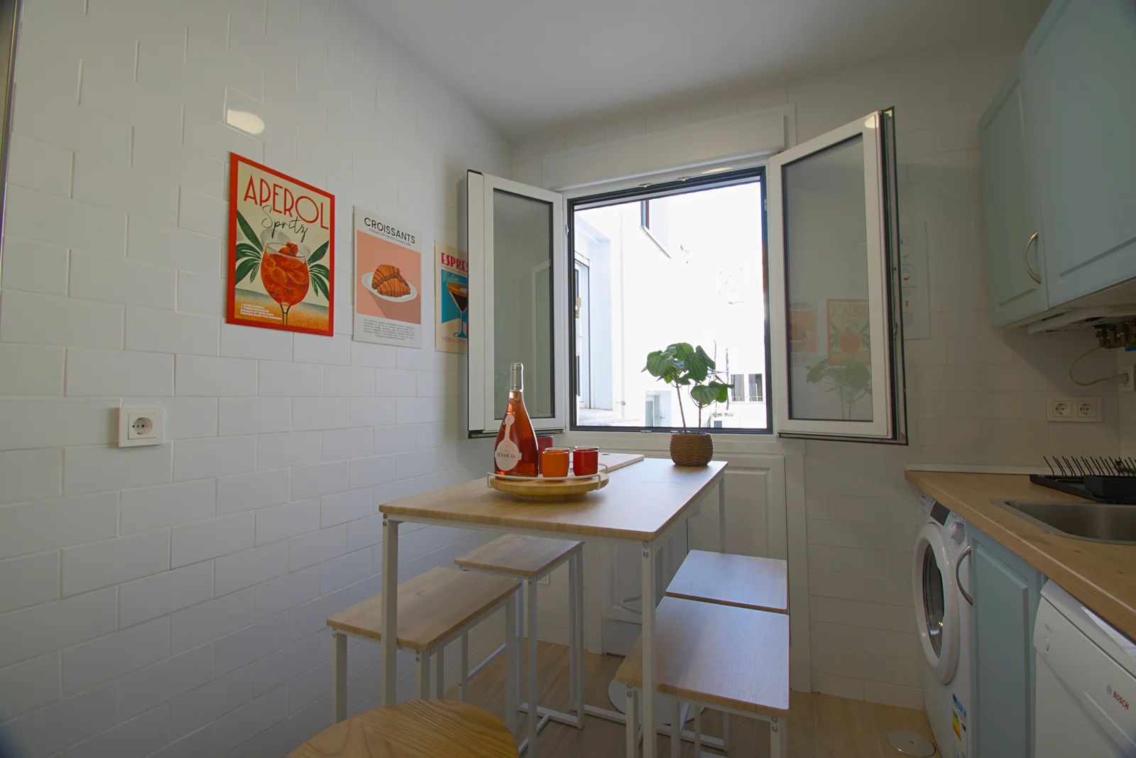 Compact eat-in nook with poster-decked walls and open windows