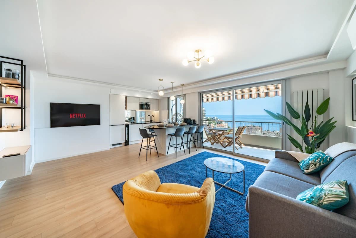 Open living, kitchen, and breakfast bar with deep-blue rug grounding the space