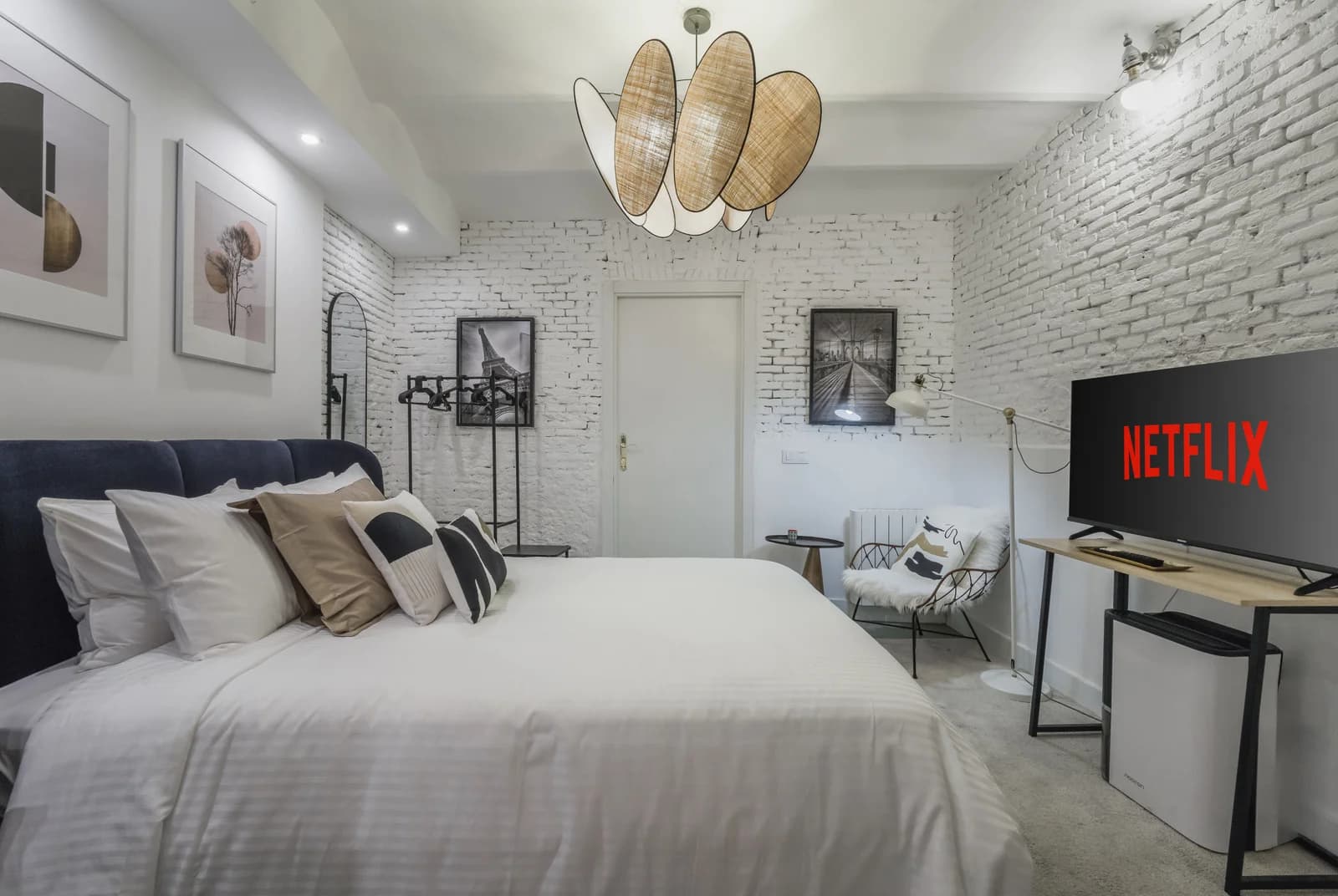Bedroom with rattan pendant cluster, brick wall art and Netflix nook
