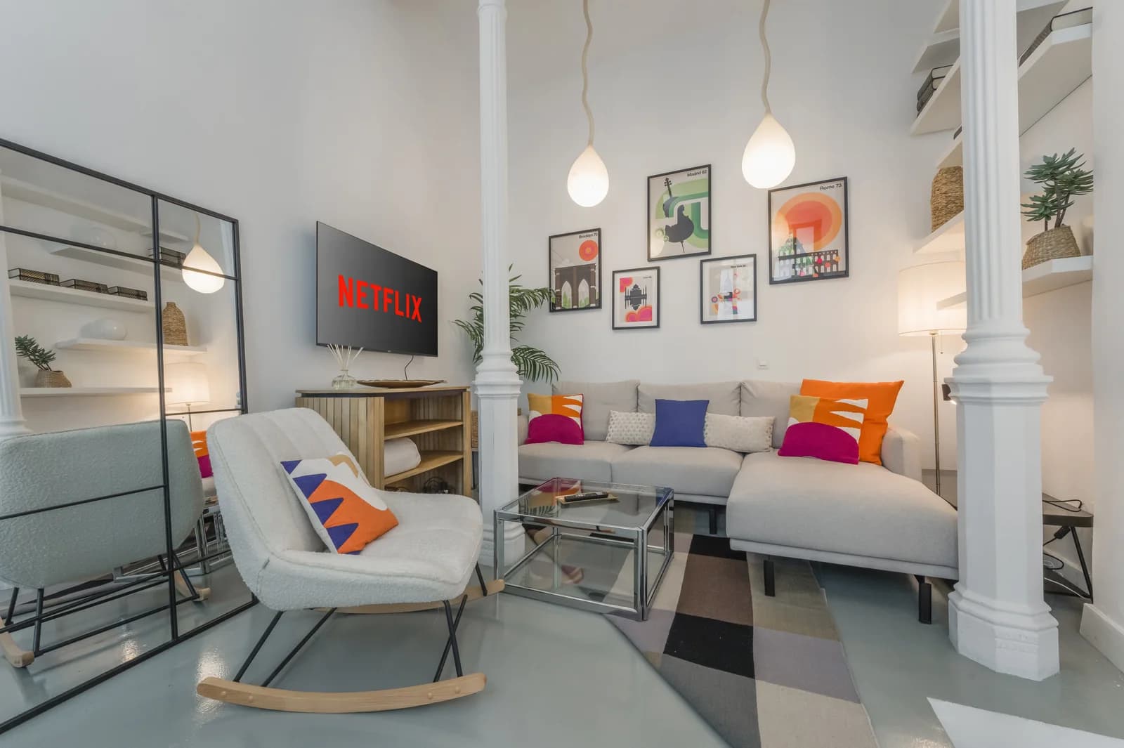 Tall living room with column, gallery wall, sectional and Madrid-poster art