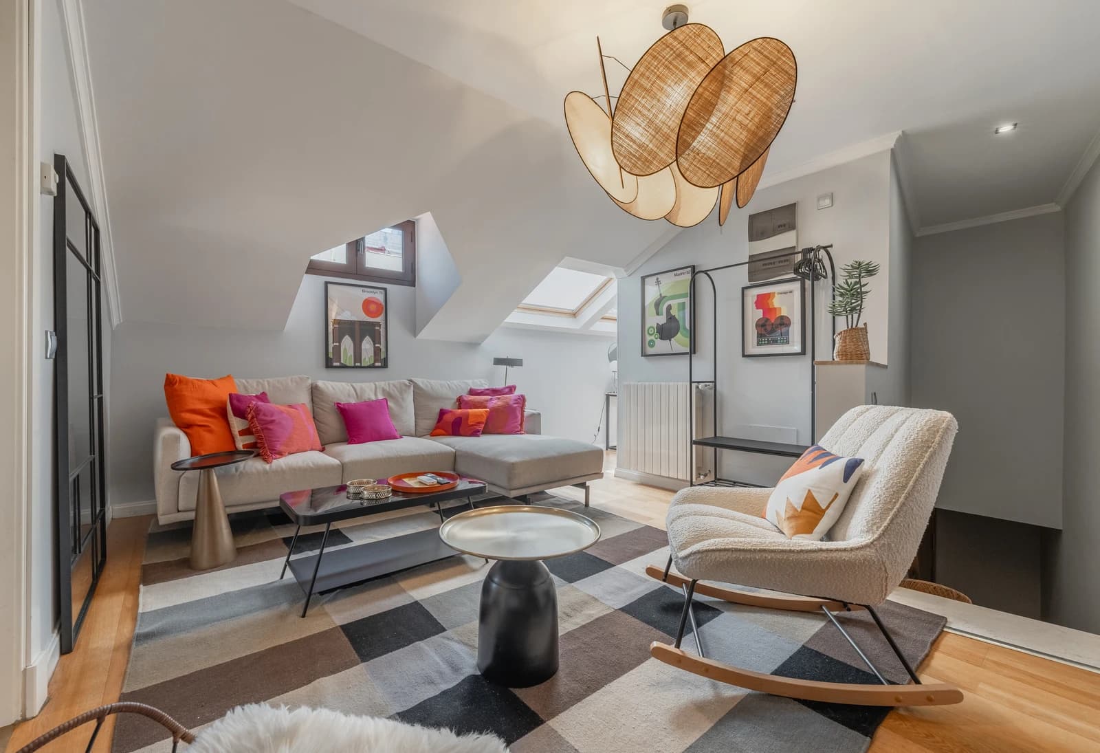 Attic living room with sculptural rattan pendant and gallery wall